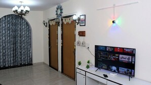 Ein Wohnzimmer mit Fernseher, einer Kristallleuchtre und einer Wanduhr.