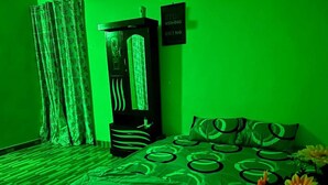 Ein Zimmer mit einem Bett, einem Nachttisch, einem Kleiderschrank und einem Schild an der Wand.