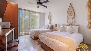 Una habitación de hotel con dos camas, un escritorio y un ventilador de techo.