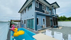 A two-story house with a swimming pool, outdoor seating, and a balcony. - Cher Cher Pool villa (Ban Chang)