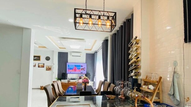 A modern dining area with a glass-top table, chairs, and a television in the background. - Cher Cher Pool villa (Ban Chang)