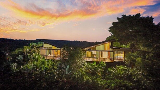 Two modern houses with large glass windows, surrounded by lush greenery. - Serene Hills Arenal (Monterrey)
