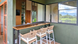 A bar area with a ceiling fan, a wooden ceiling, and a view of the outdoors. - Serene Hills Arenal (Monterrey)