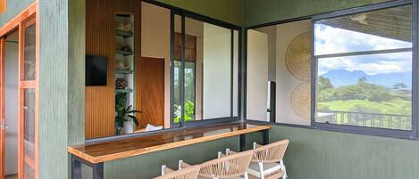 A bar area with a ceiling fan, a wooden ceiling, and a view of the outdoors.