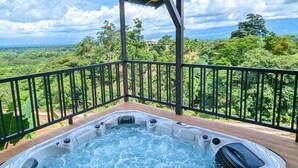 A hot tub on a wooden deck with a view of a lush landscape. - Serene Hills Arenal (Monterrey)