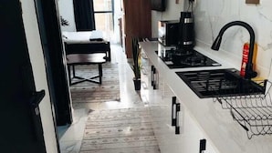Cozinha moderna com ilha central, torneira preta e micro-ondas.