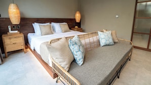 A bedroom with a large bed, two bedside tables, a nightstand, and a wicker sofa. - Damarya Villa Canggu (Canggu)
