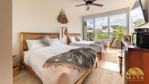 A hotel room with two beds, a ceiling fan, a large window with a view, and a flat-screen TV. - NHOA 305A Lux 2BR Pool View Aldea Zama (Tulum)