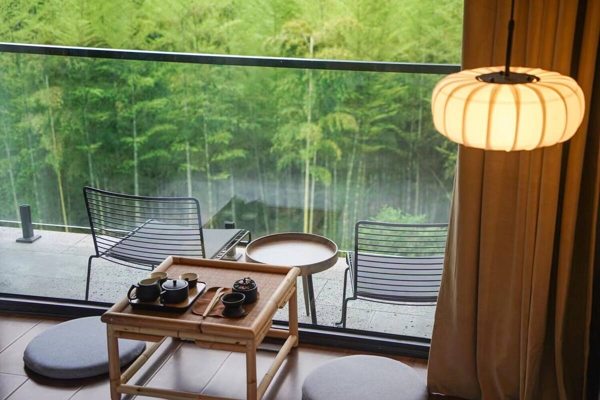 A balcony with two chairs, a small table, and a tray with tea and cups.