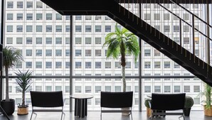 A modern interior with a staircase, large windows, and several seating areas. - HOMESRED MYEONGDONG (Seoul)