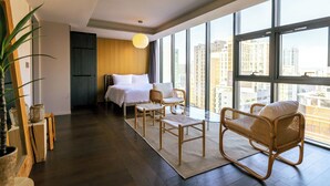 A modern hotel room with a large window, a bed, two wicker chairs, and a small table. - HOMESRED MYEONGDONG (Seoul)