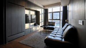 A modern living room with a leather sofa, a flat-screen TV, and a large window with curtains. - HOMESRED MYEONGDONG (Seoul)