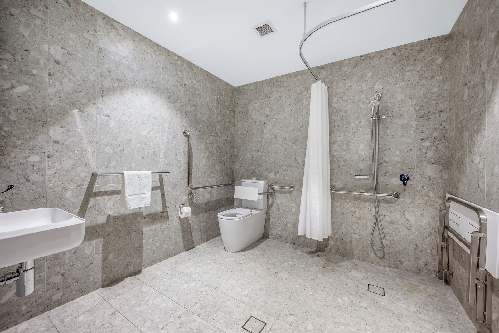 Une salle de bain moderne équipée d’une douche, de toilettes et d’un lavabo.