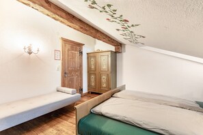Une chambre à coucher avec un lit en bois, un banc et une armoire.
