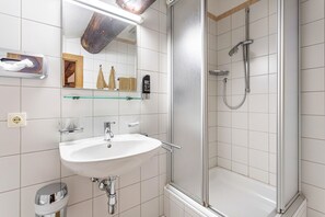 A bathroom with a white sink, a glass shower enclosure, and a mirror above the sink. - Room 'Fuchswirt 01 - Doppelzimmer' with Mountain View, Shared Garden and Wi-Fi (Kelchsau)