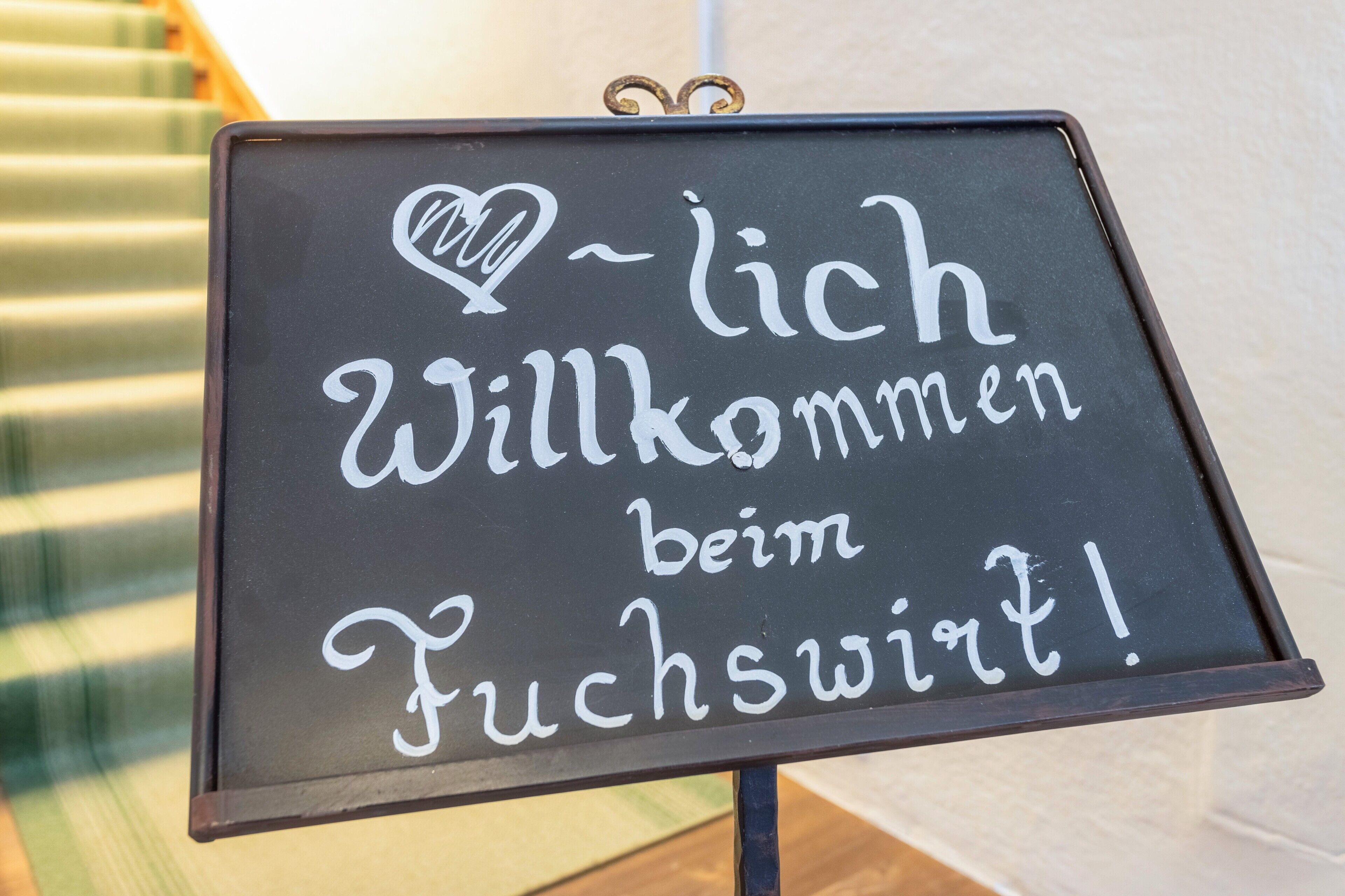 A sign with the text 'Willkommen beim Fuchswinkel!'