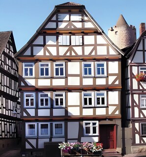 A traditional half-timbered building with multiple windows and a red door.