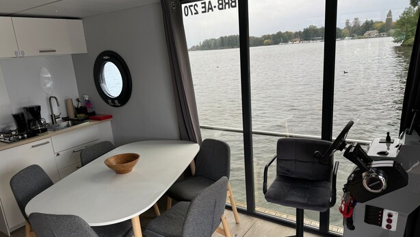 Ein modernes Interieur mit Küche, Essbereich und Blick auf das Wasser.