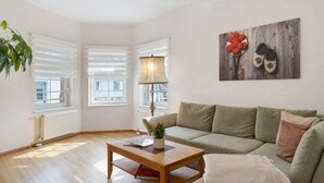 A living room with a wooden coffee table, a sofa, a lamp, and a painting on the wall.