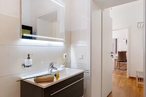 A modern bathroom with a large mirror, a white sink, and a dark vanity. - Apartment 'Ferienwohnung Silberbergblick' with Wi-Fi (Todtnau)