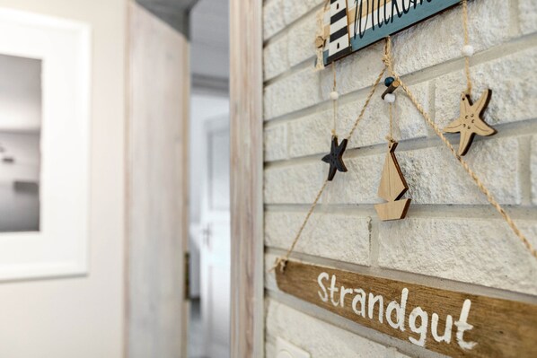 Een houten bordje met de tekst 'strandgut' aan een structuurrijke muur.