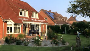 Een gebouw van rode bakstenen met een bord waarop 'Strandgut' en 'Wellenreiter' staat.