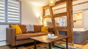 A living room with a brown sofa, yellow cushions, a wooden coffee table, and a colorful rug. - Apartment '3' in Bodman-Ludwigshafen (Bodman-Ludwigshafen)