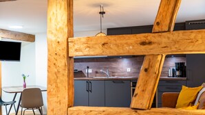 A modern kitchen with dark cabinets, a stainless steel sink, and a hanging light fixture. - Apartment '3' in Bodman-Ludwigshafen (Bodman-Ludwigshafen)