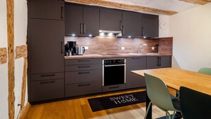 A modern kitchen with dark cabinets, a wooden countertop, and a built-in oven. - Apartment '2' in Bodman-Ludwigshafen (Bodman-Ludwigshafen)