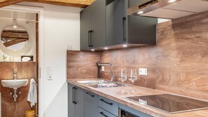 Una cocina moderna con encimera de madera, electrodomésticos integrados y un espejo grande.