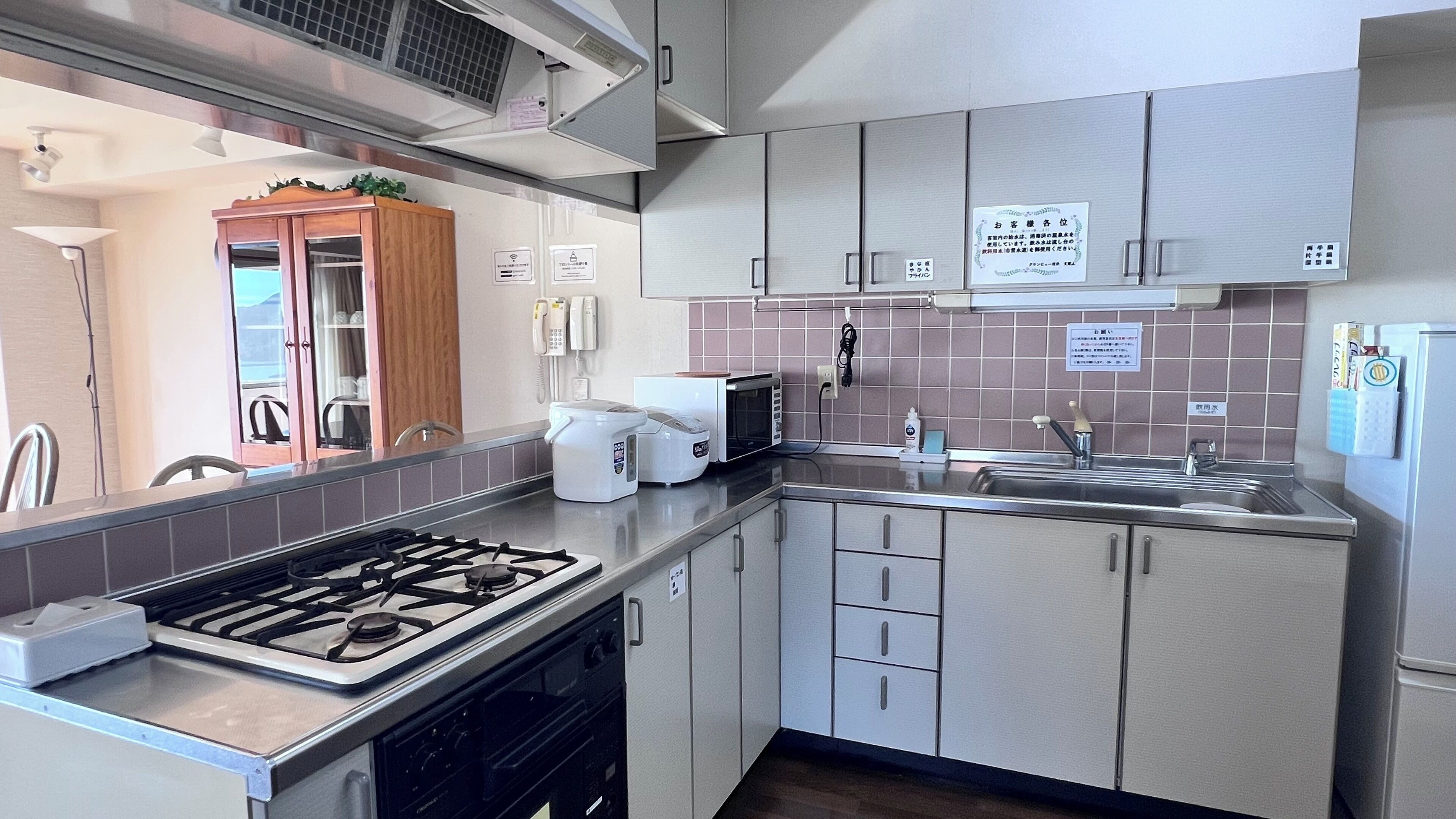 A compact kitchen with a gas stove, microwave, sink, and cabinets.