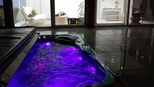 Un jacuzzi con vista a un comedor y una cocina al fondo.