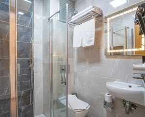A modern bathroom with a glass-enclosed shower, a toilet, and a sink. - GRAND REİS HOTEL (Istanbul)
