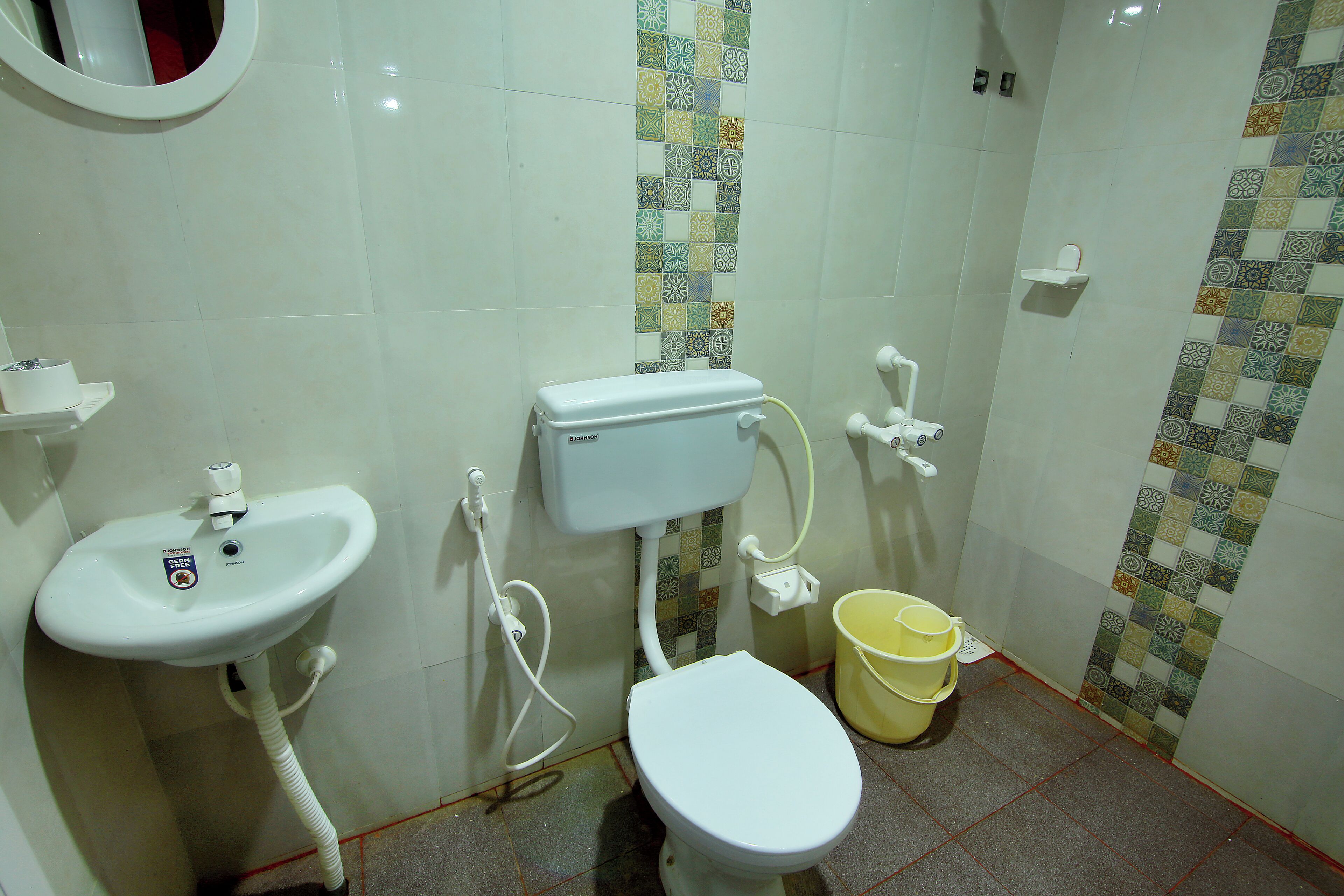 A bathroom with a toilet, sink, and a small shelf.