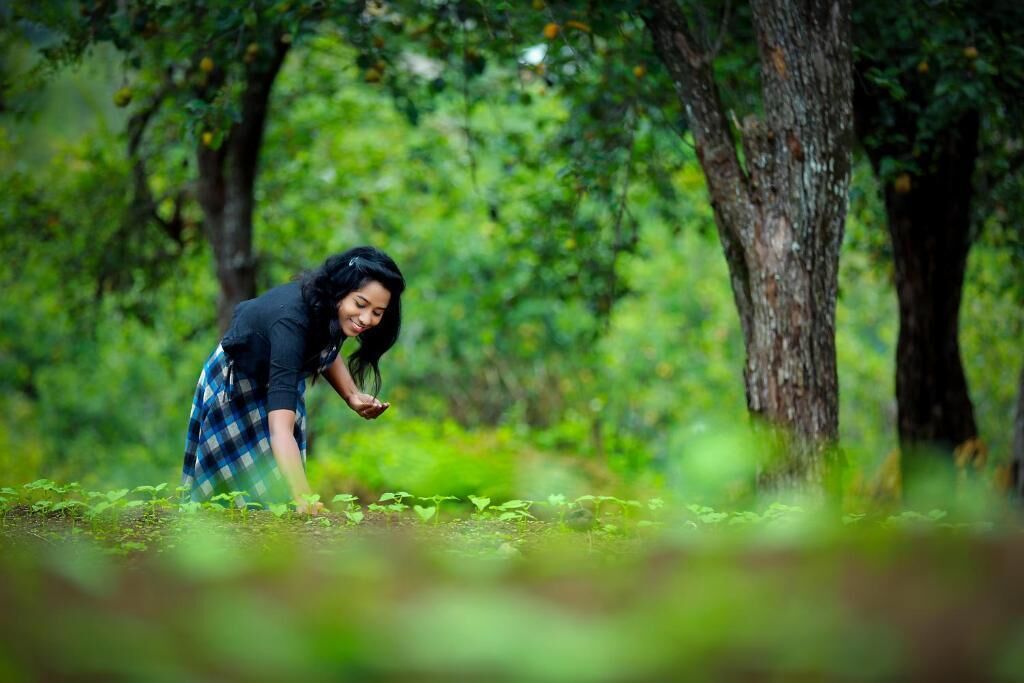 A person in a forested area with trees and greenery.