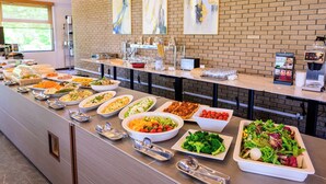 Ein Buffet mit verschiedenen Speisen und einer Kaffeemaschine.