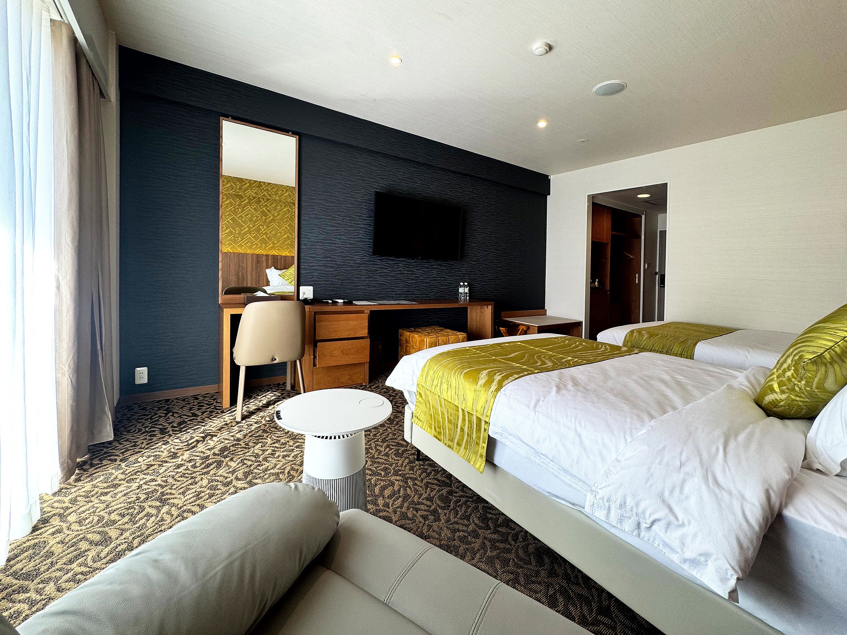 Una camera d'albergo con un letto, una scrivania, una sedia e una televisione.