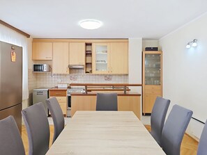 Cozinha moderna com armários de madeira, uma mesa de jantar e cadeiras.