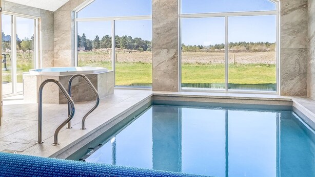 A modern indoor swimming pool with large windows and a view of the outdoors. - "Sönke" - 4km from the sea by Interhome (Rømø)