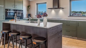 A modern kitchen with a central island, bar stools, and pendant lighting. - "Sönke" - 4km from the sea by Interhome (Rømø)