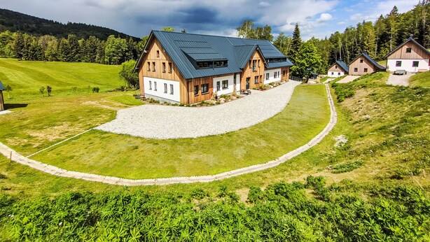 A large wooden house with a sloped roof, surrounded by a well-maintained lawn and a gravel driveway. - Markéta by Interhome (Smržovka)