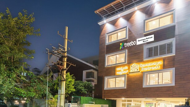 Un bâtiment moderne avec une enseigne indiquant « Sanmaya Retreat Mysore » et « treebo ».