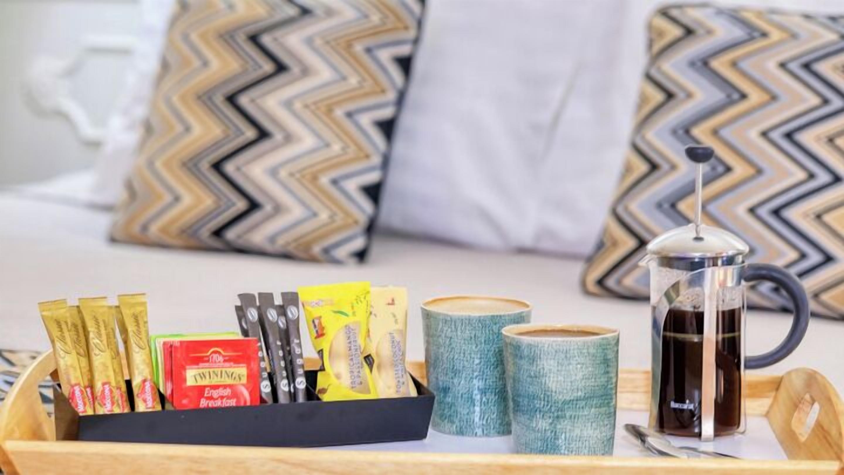 A tray with breakfast items including coffee, tea, and snacks.