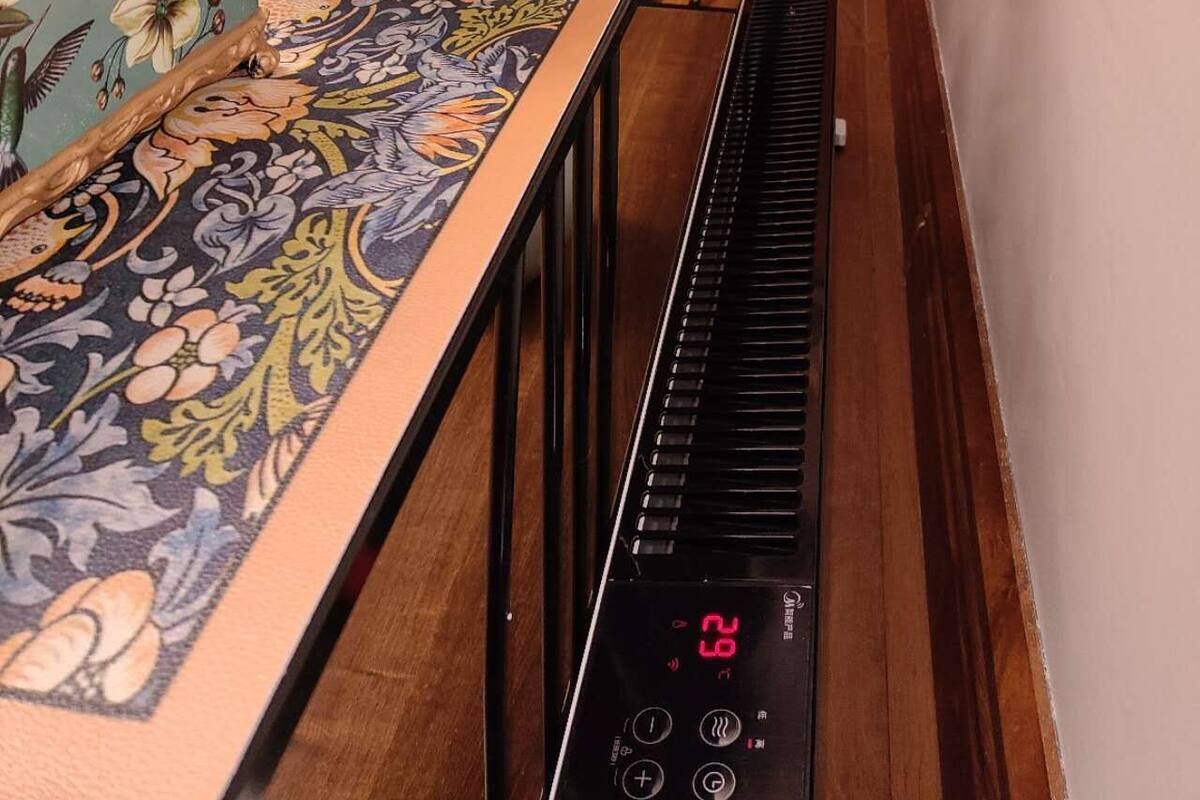 Un piano doté d’un écran numérique, un vase à fleurs et un chemin de table décoratif.