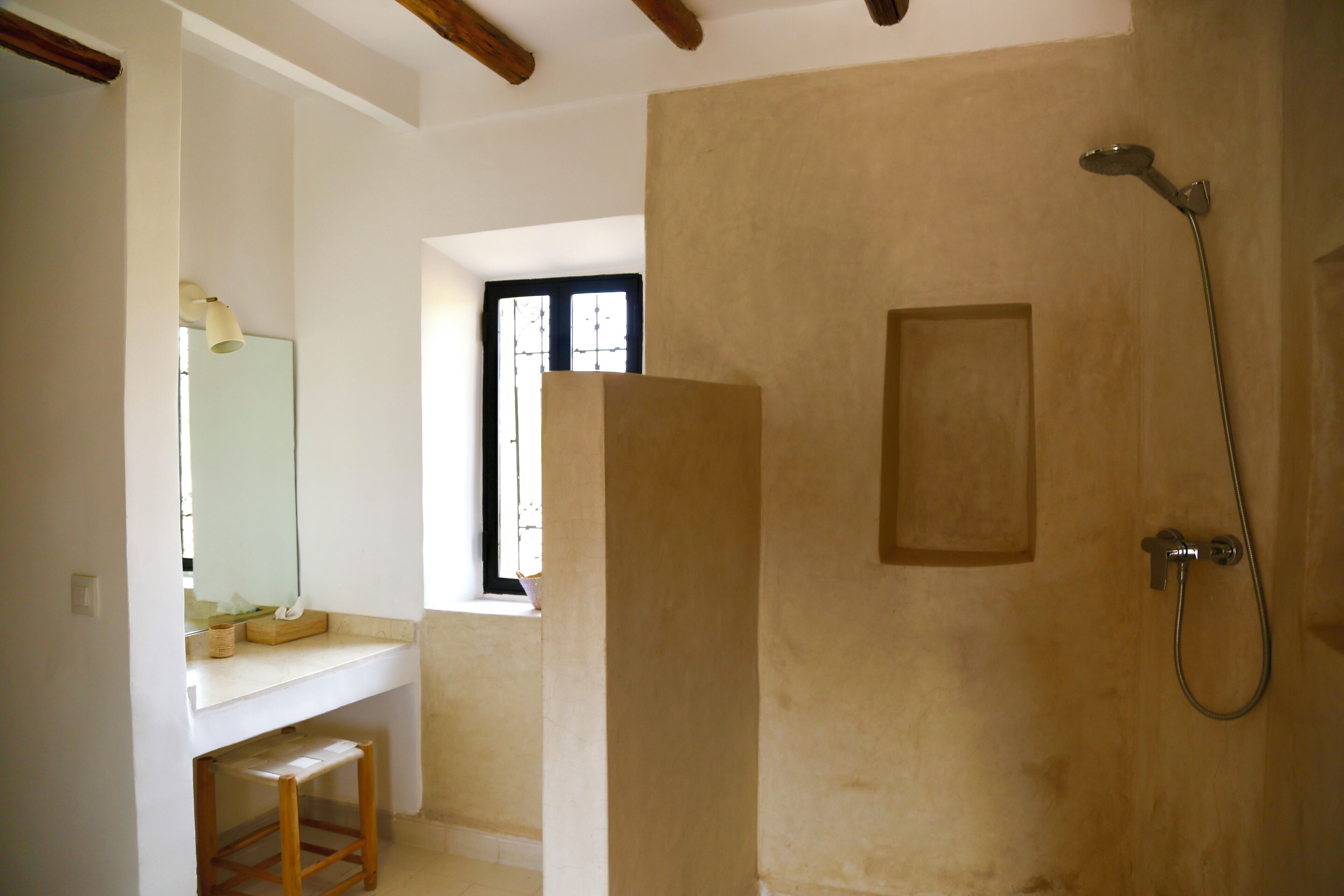 A bathroom with a shower, a sink, and a mirror.