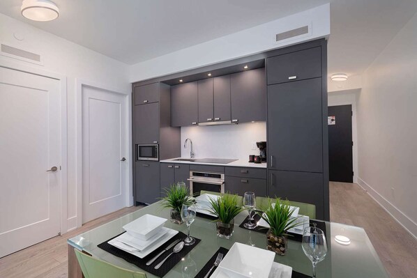 A modern kitchen with dark cabinets, a microwave, and a coffee maker.