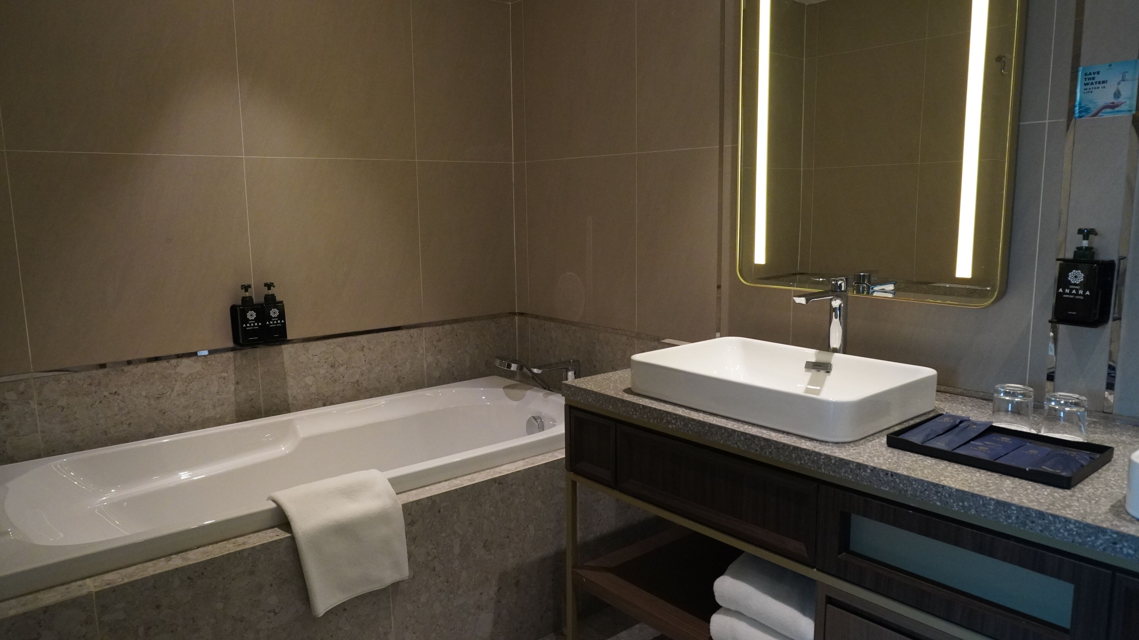 A modern bathroom with a bathtub, a sink, and a large mirror.