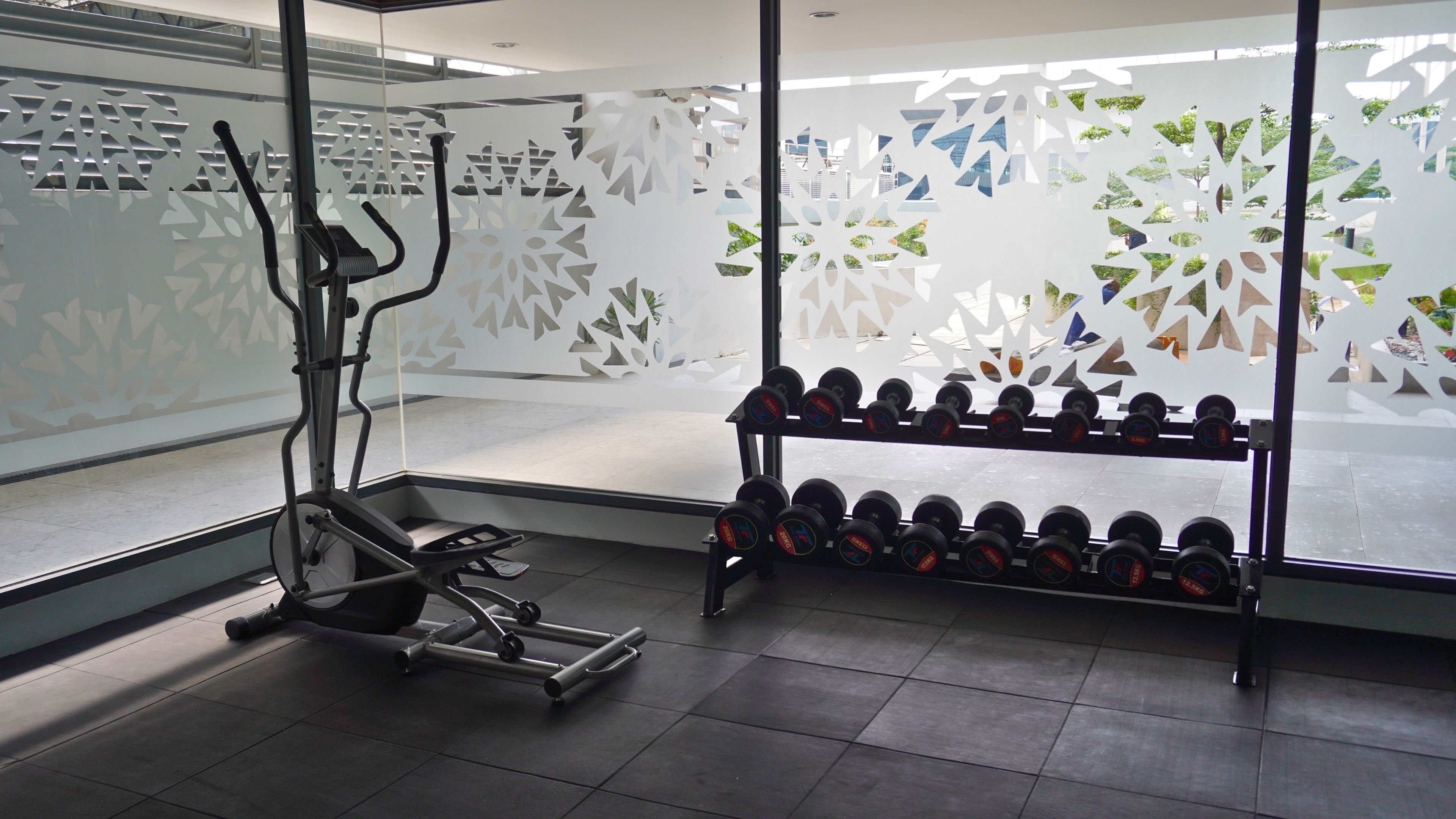A gym with exercise equipment, including a treadmill and a rack of dumbbells.