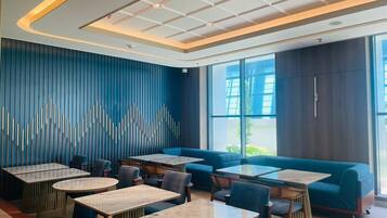 Un interior de restaurante moderno con una decoración azul y blanca, que incluye mesas y zonas de estar.