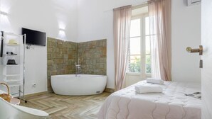 Un baño moderno con una bañera independiente, un lavabo blanco y un mueble de tocador.